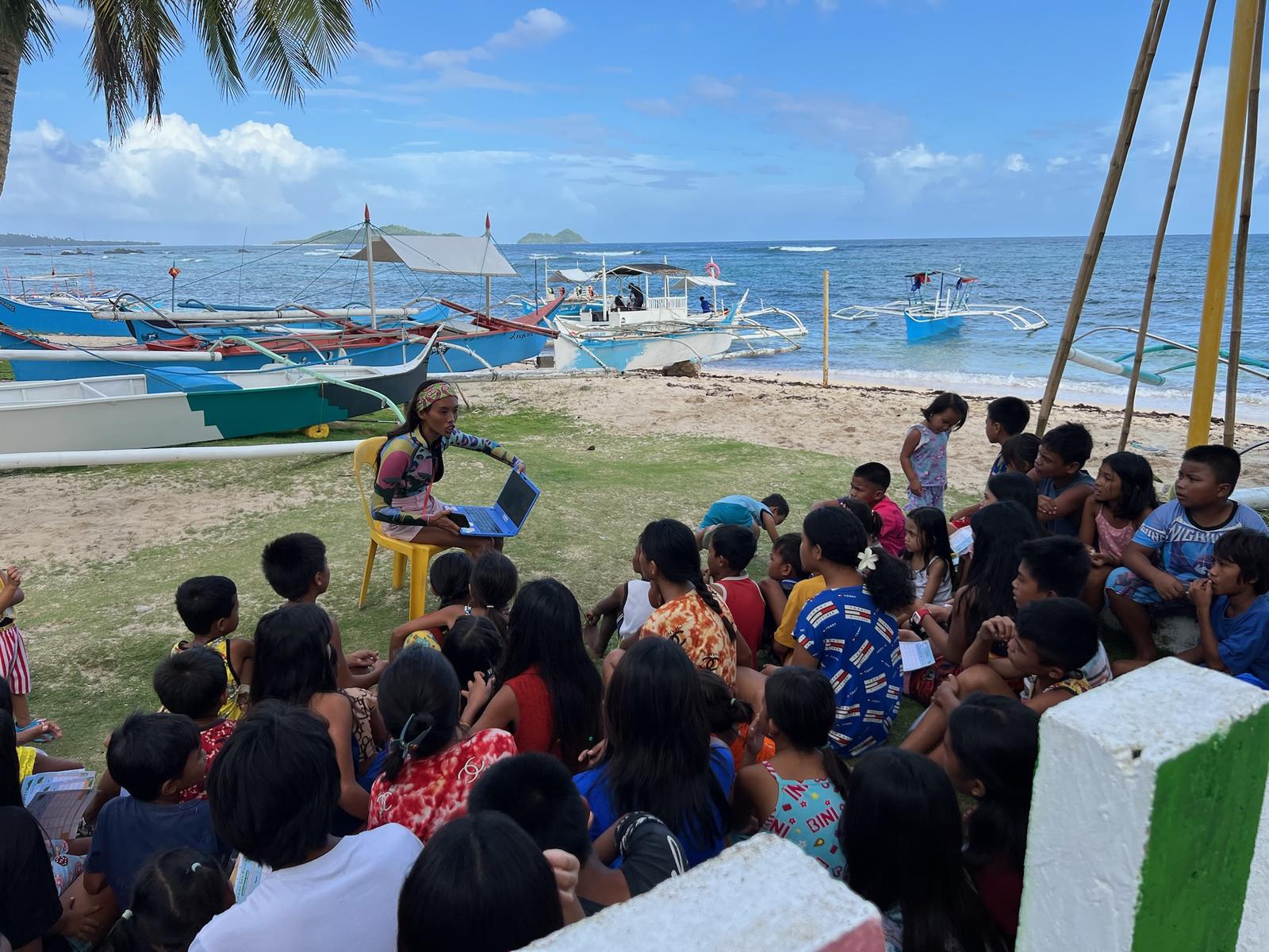 Children gathered on the beach for an ocean workshop